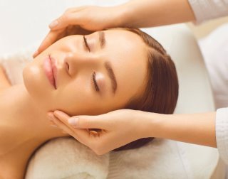 Gesichtsbehandlung: sanfte Massage des Gesichts auf der Liege
