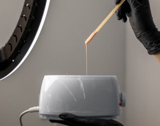 Waxing: Warmwachs wird für die Haarentfernung vorbereitet